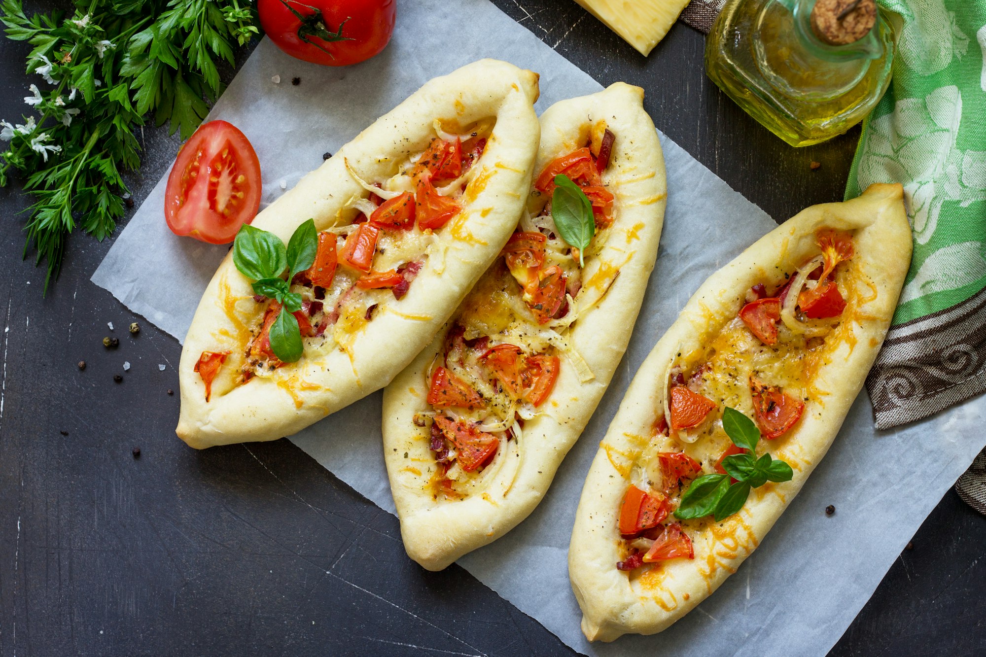 Delicious homemade Greek oval pizza with salami, tomato, onion and cheese.